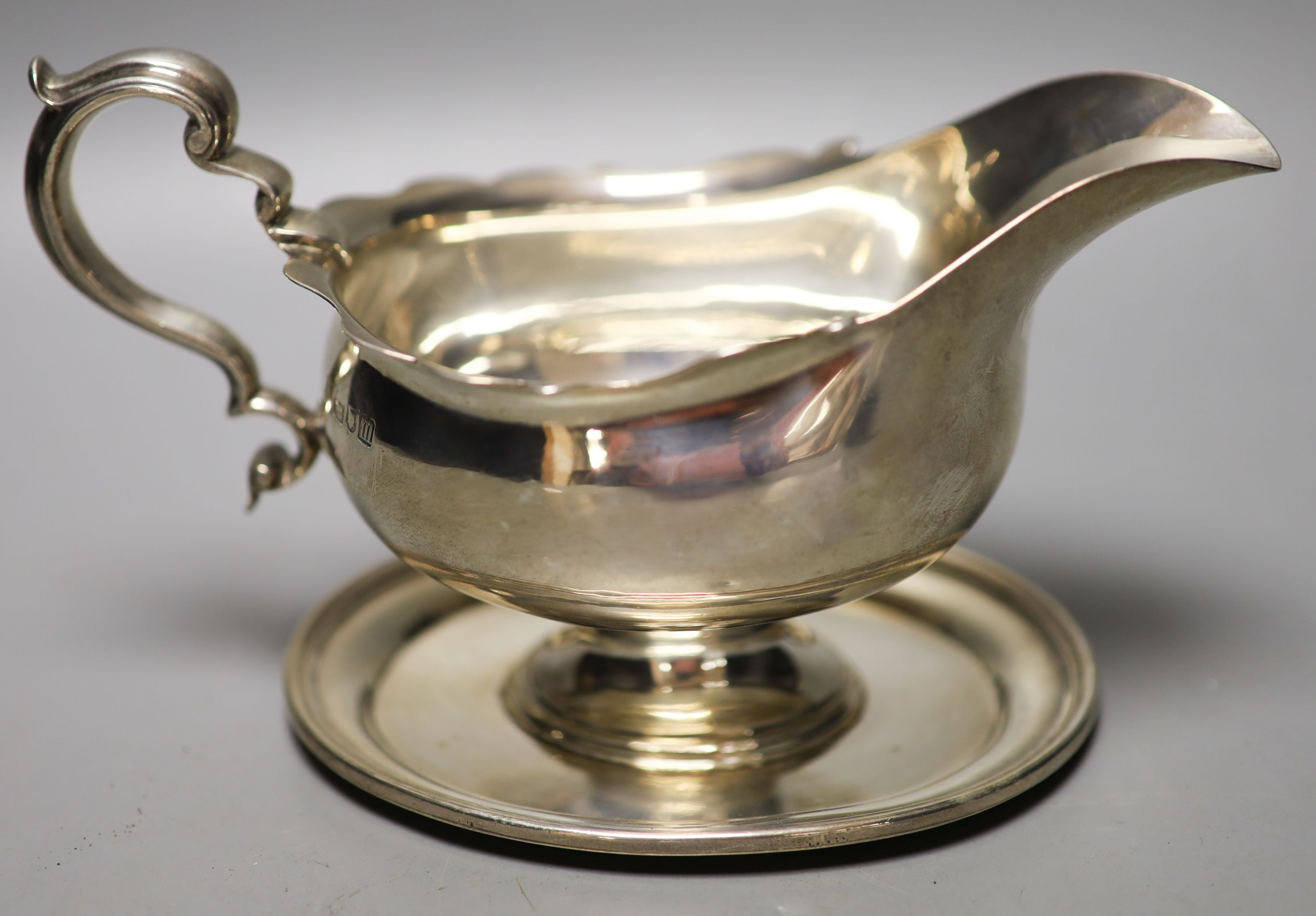 An Edwardian silver pedestal sauceboat on oval base, Thomas Bradbury & Sons, London, 1907, width 19.5cm, 140z.